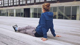 Woman in Blue Hoodie Sitting on Wooden Deck