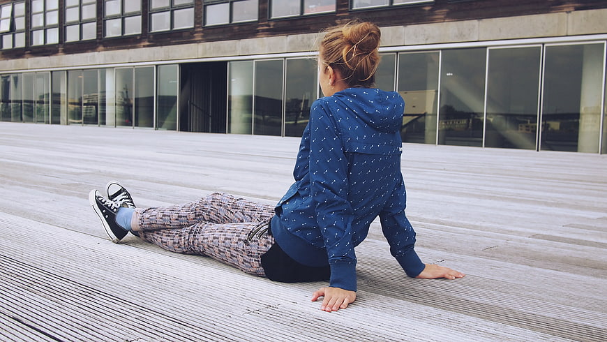 Woman in Blue Hoodie Sitting on Wooden Deck