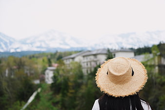 Woman in Straw Hat Viewing Snowy Mountain Landscape