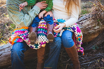 Family in Cowboy Boots Sitting on Log with Crochet Blanket