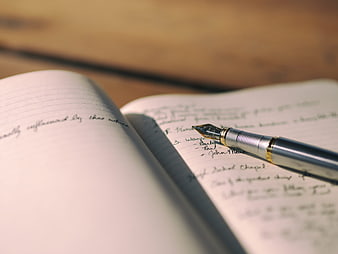 Close-up of fountain pen on handwritten notebook notes