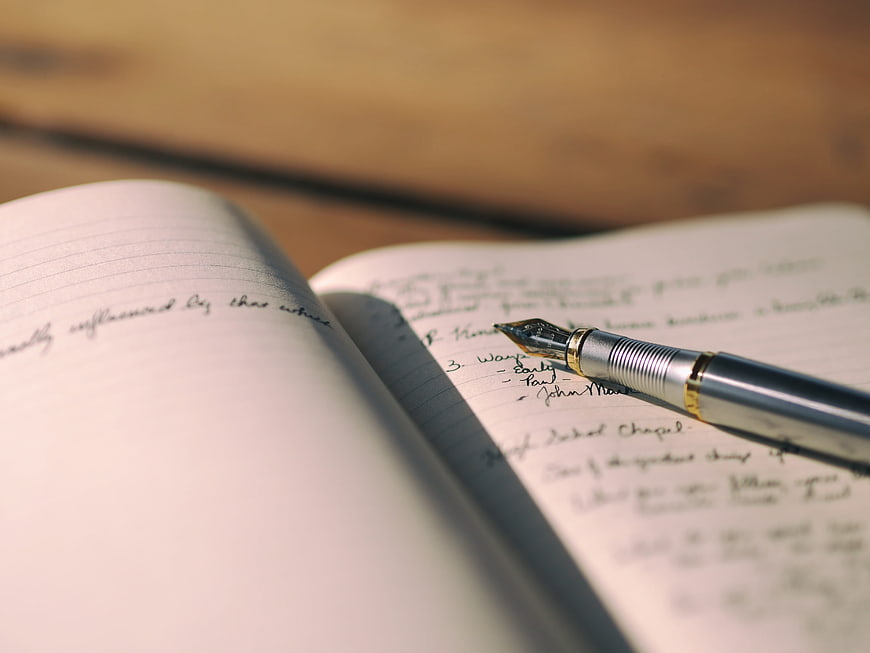 Close-up of fountain pen on handwritten notebook notes
