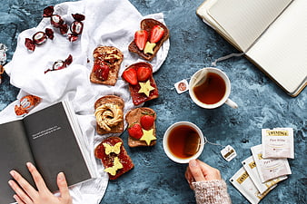 Top view of sweet toast, tea, and books on blue background
