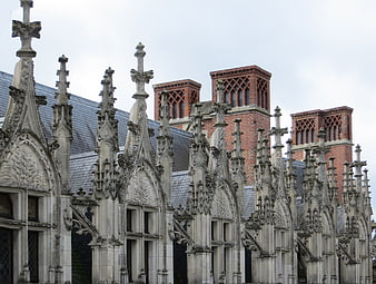 Gothic stone buttresses and brick chimneys on historic European architecture