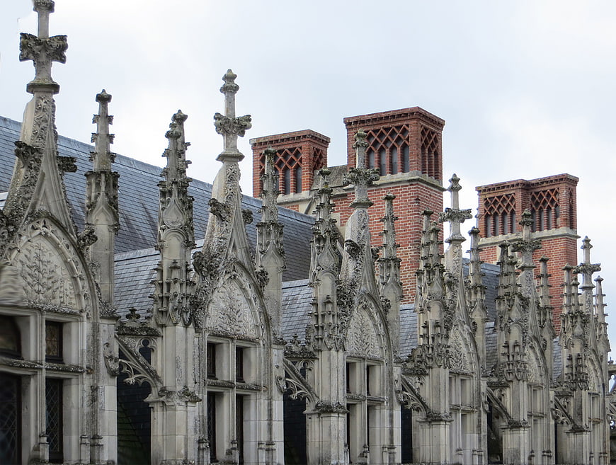 Gothic stone buttresses and brick chimneys on historic European architecture