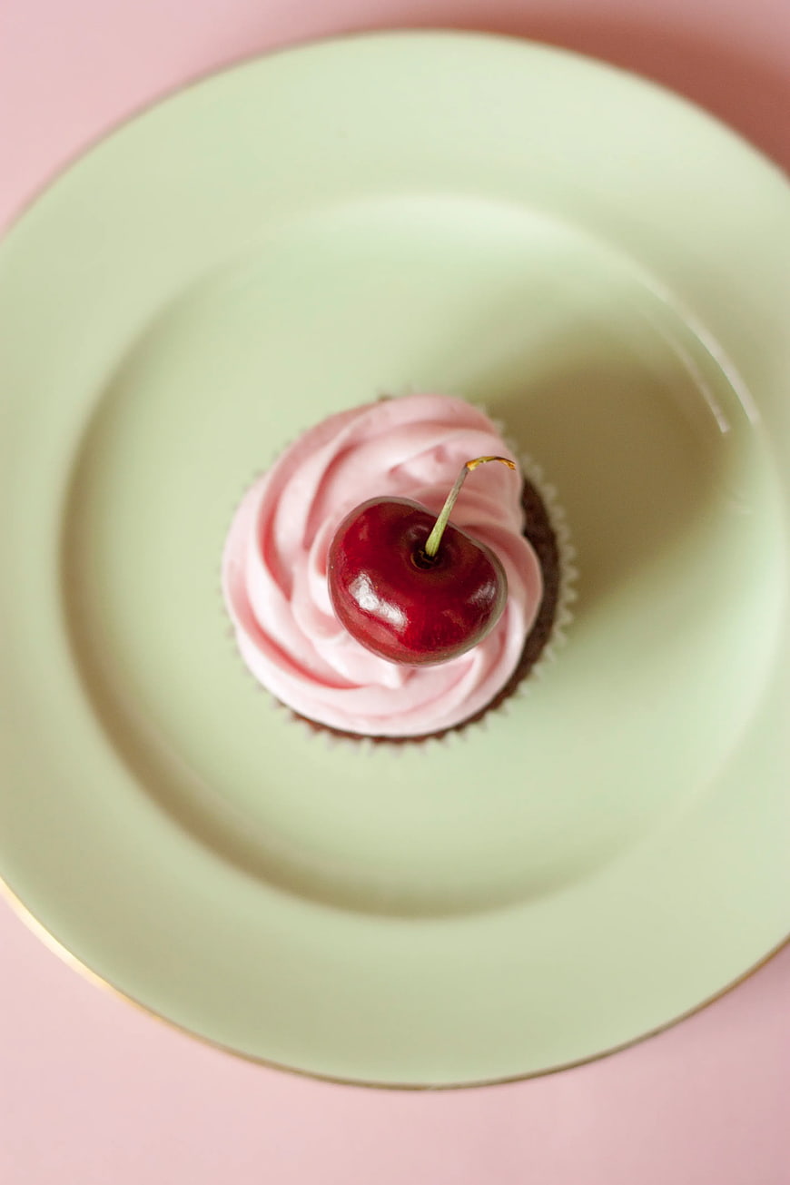 Top View of Pink Cupcake with Cherry on Mint Plate