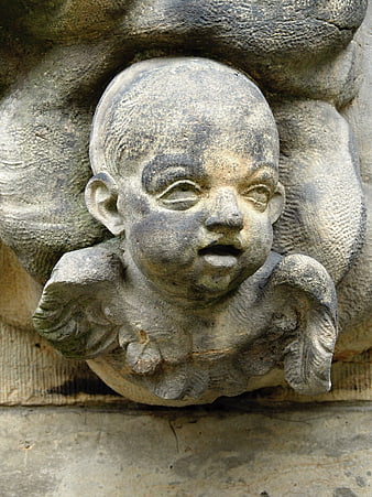 Close-up of weathered stone angel face sculpture