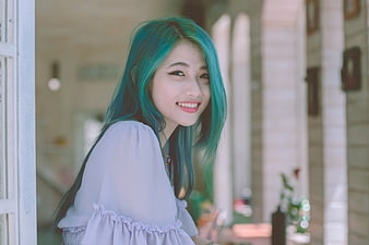 Smiling Woman with Teal Hair Looking Over Shoulder