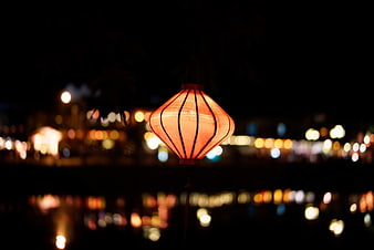 Glowing red lantern with bokeh lights at night