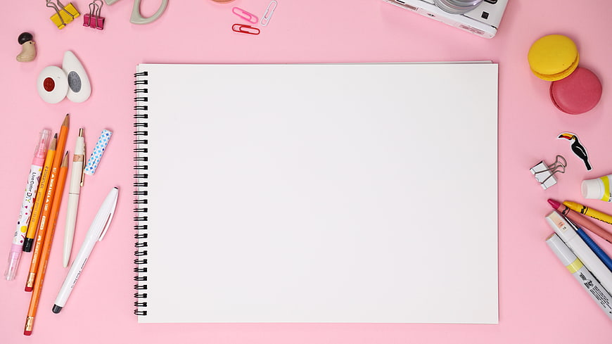Flat lay of blank sketchbook with stationery on pink background