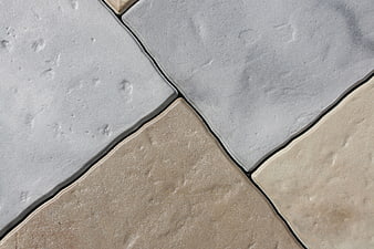 Close-up of gray and beige stone tiles with dark grout lines