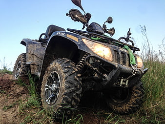 Muddy Arctic Cat ATV Stuck in Off-Road Terrain