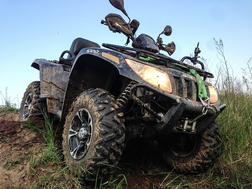 Muddy Arctic Cat ATV Stuck in Off-Road Terrain