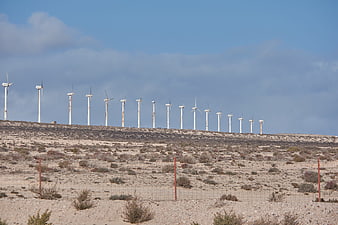 Row of wind turbines on desert hill ridge