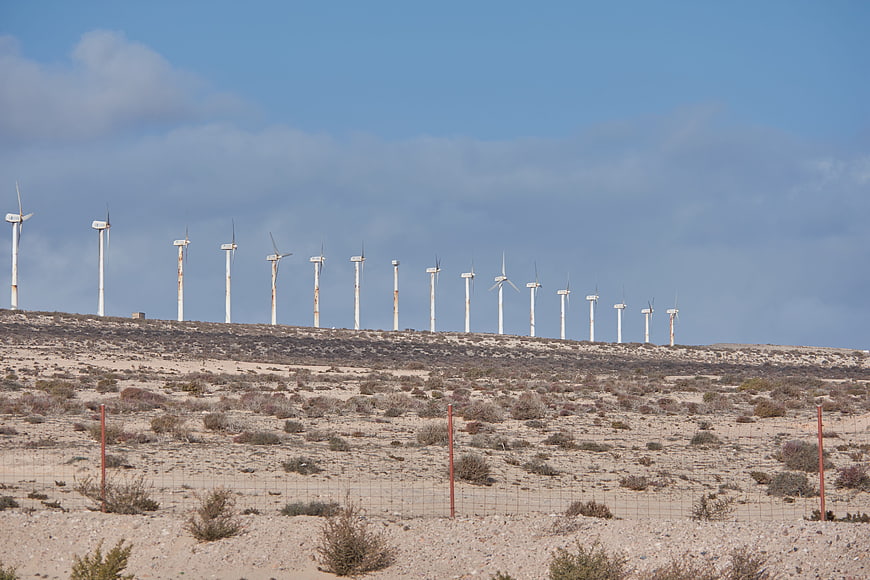 Row of wind turbines on desert hill ridge