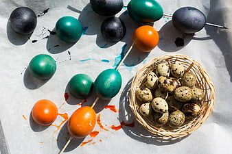 Top view of dyed Easter eggs and quail eggs in a basket