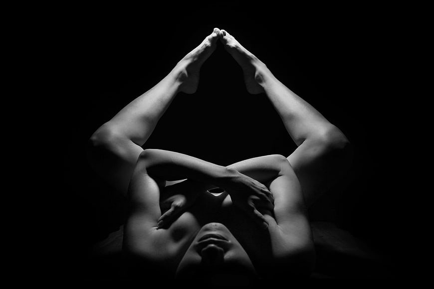 Black and white artistic yoga pose with dramatic lighting