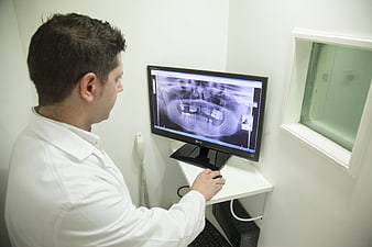 Dentist analyzing digital panoramic x-ray on computer monitor