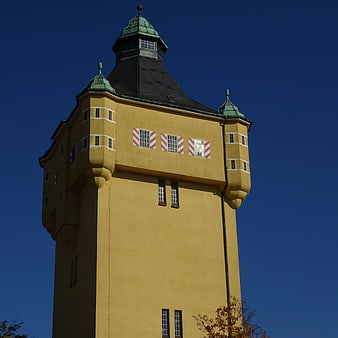 Yellow Historic Water Tower Against Blue Sky