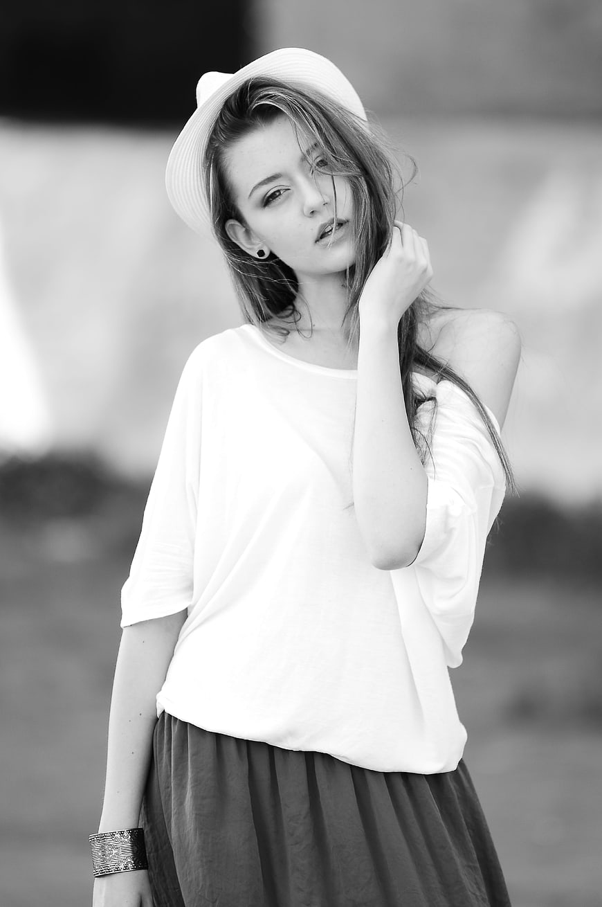 Black and white portrait of stylish young woman in hat