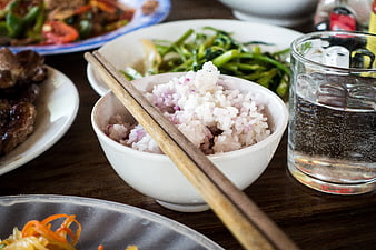 Bowl of rice with chopsticks and side dishes