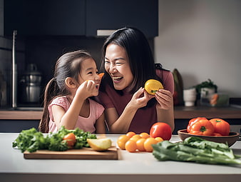 Mother and daughter laughing with fresh vegetables in kitchen