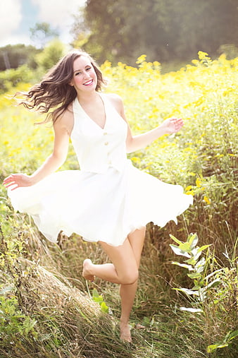Happy Woman in White Dress Running Through Wildflower Field