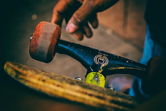 Close-up of worn skateboard truck and hand