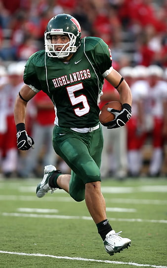 American Football Player Running with Ball in Green Highlanders Jersey