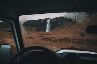 View of Skógafoss waterfall from inside a car in Iceland