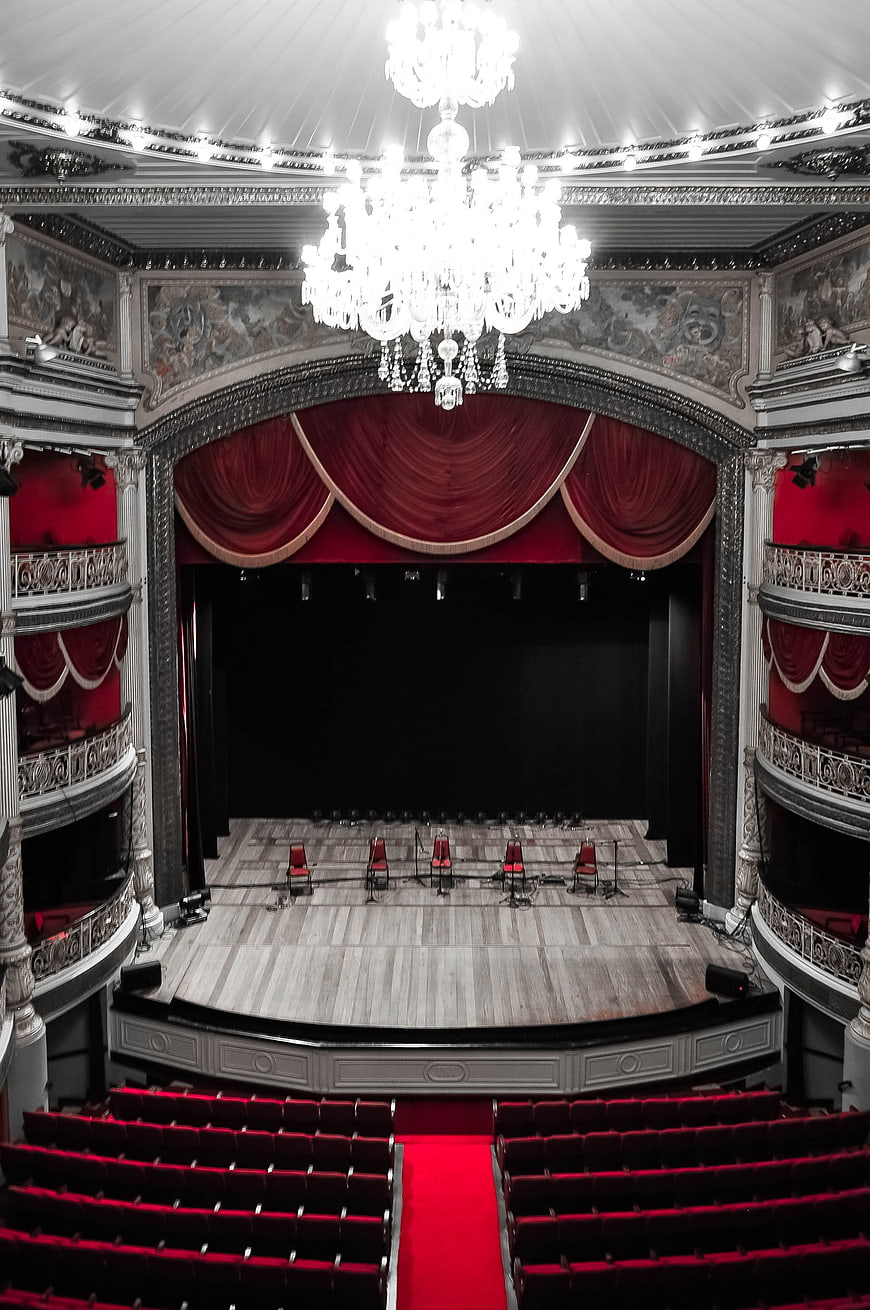 Grand Theater Interior With Red Curtains And Chandelier