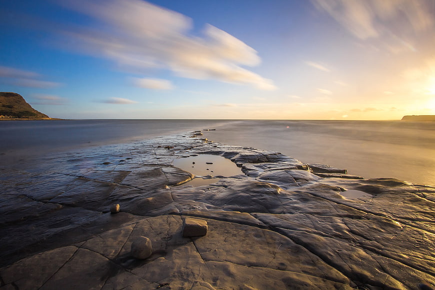 Long Exposure Sunset Over Rocky Coastal Shoreline
