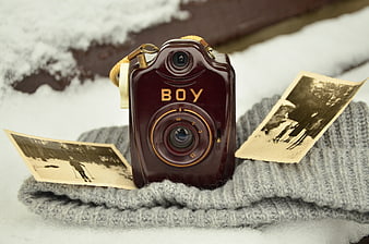 Vintage Boy Box Camera with Old Photos in Snow