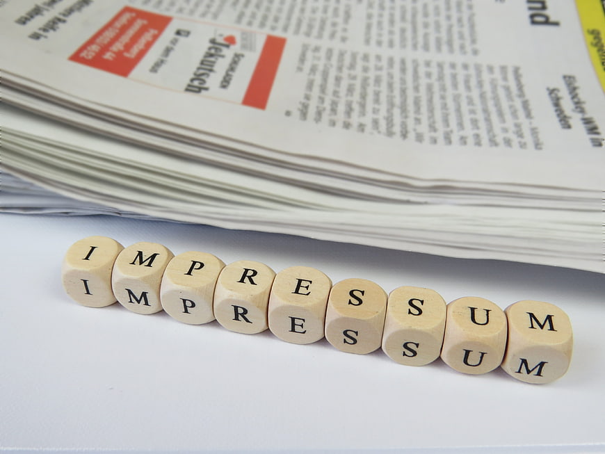 Wooden Scrabble Tiles Spelling Imprimatur On White Surface Near Newspaper