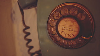 Close-up of vintage rotary telephone dial with warm lighting