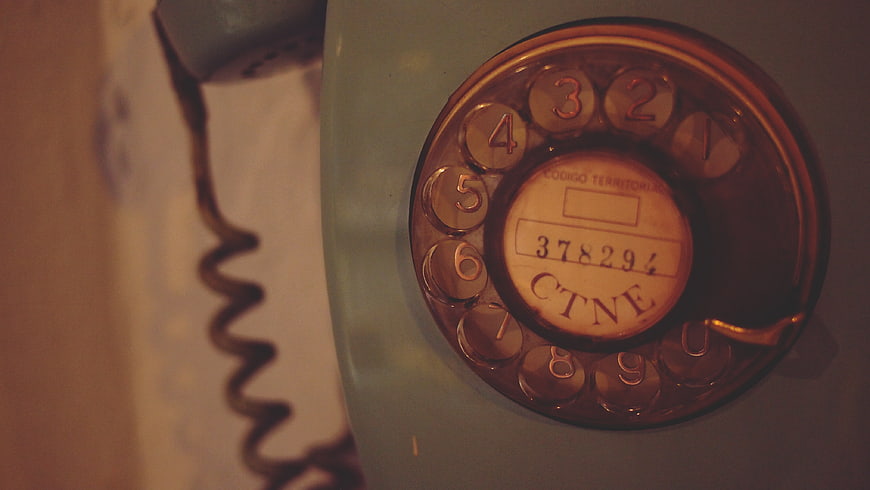Close-up of vintage rotary telephone dial with warm lighting