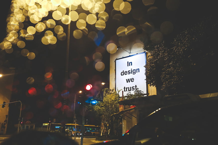In Design We Trust Billboard Night Rain Bokeh