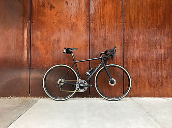 Black Road Bicycle Against Rusty Metal Wall