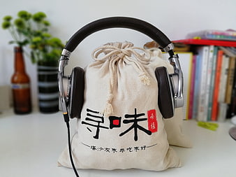 Headphones resting on a canvas bag with Chinese calligraphy