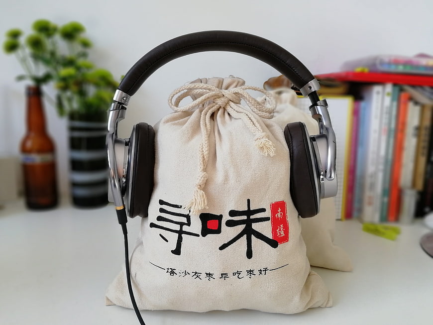 Headphones resting on a canvas bag with Chinese calligraphy