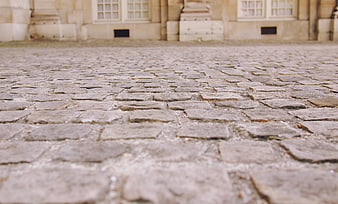 Low Angle View of Old Cobblestone Street with Blurred Building