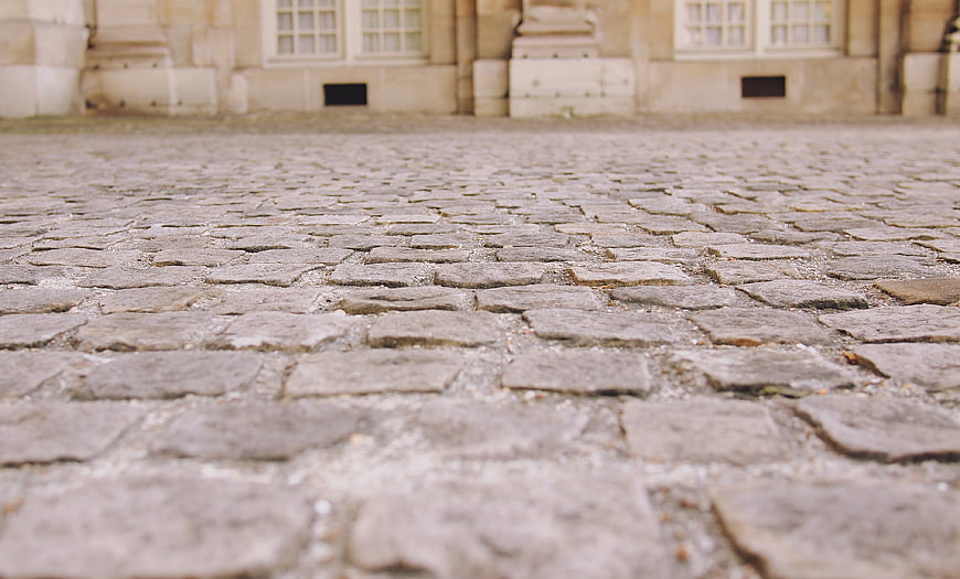 Low Angle View of Old Cobblestone Street with Blurred Building