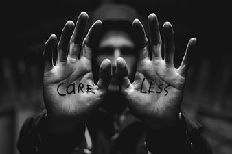 Man holding hands with CARELESS written on palms