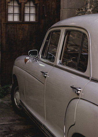 Vintage Silver Car Parked Near Wooden Door