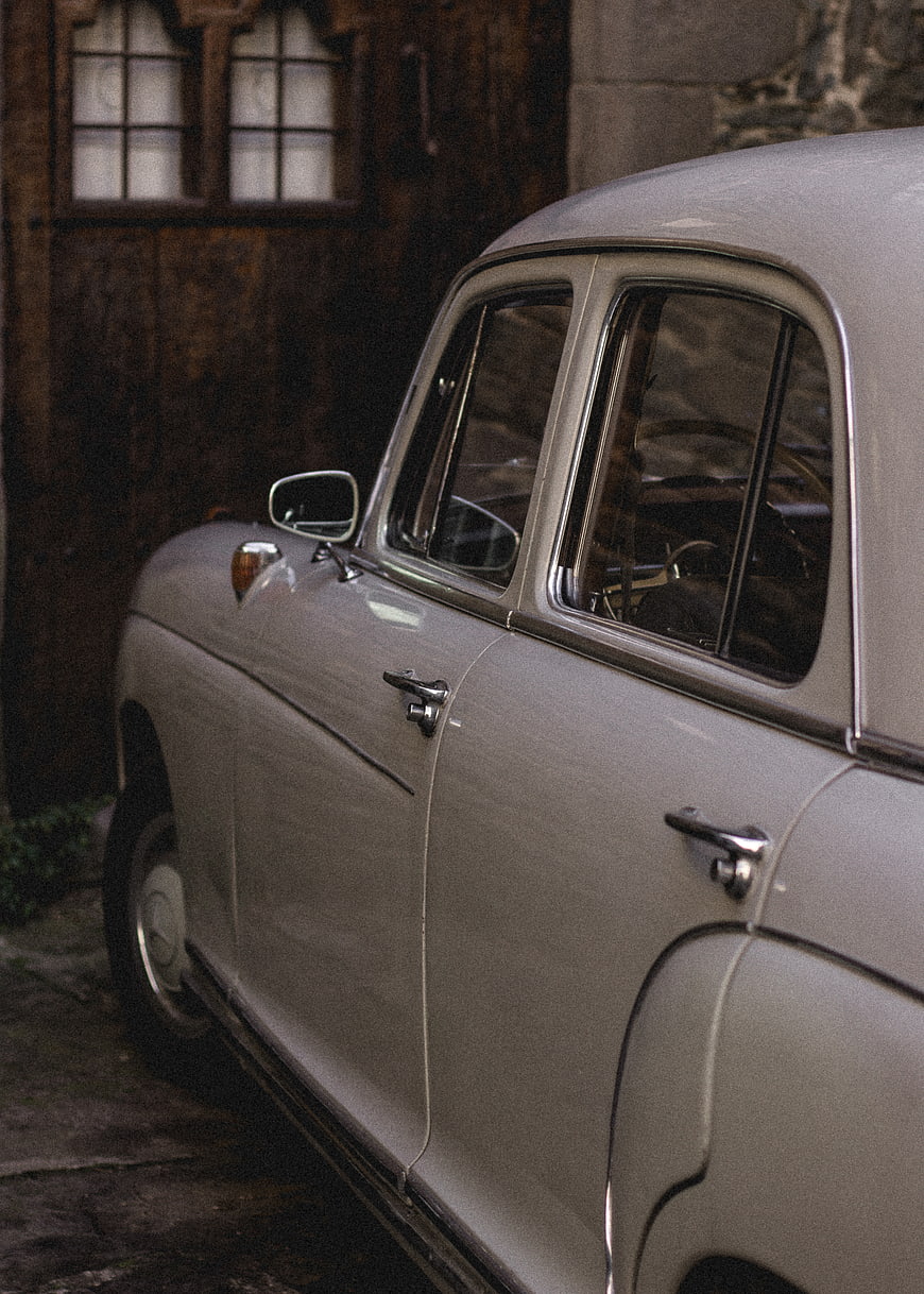Vintage Silver Car Parked Near Wooden Door