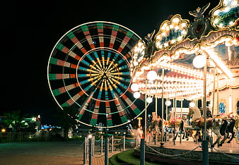Illuminated Ferris Wheel and Carousel at Night in Amusement Park