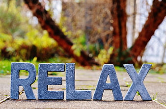 Blue RELAX letters on stone path in park