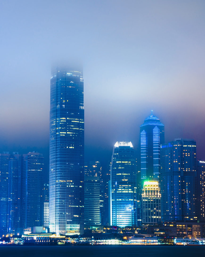 Foggy Hong Kong skyline at night with illuminated skyscrapers