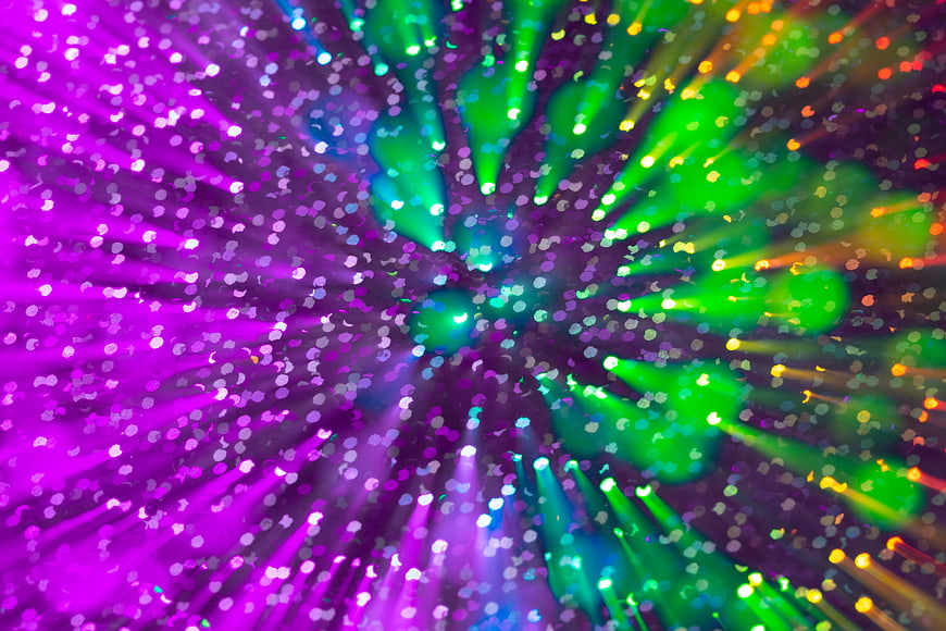 Abstract colorful bokeh explosion with purple and green light particles