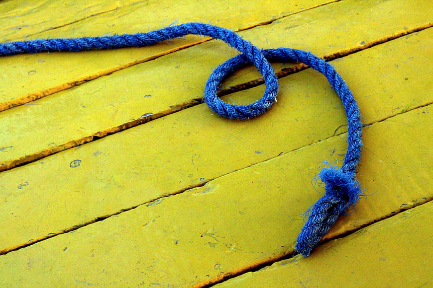 Blue rope loop on yellow wooden planks background